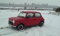 Mini in the snow with lights on
